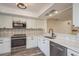 Modern kitchen with stainless steel appliances, white cabinets, and patterned backsplash at 3130 Eagles Landing W Cir, Clearwater, FL 33761