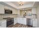 Well-lit kitchen featuring stainless steel appliances, white cabinets, and an open layout at 3130 Eagles Landing W Cir, Clearwater, FL 33761