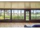 Enclosed porch with tile flooring that looks out to the landscaping and golf course at 3130 Eagles Landing W Cir, Clearwater, FL 33761