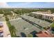 Aerial shot of tennis courts next to condos and a parking area surrounded by green trees at 3130 Eagles Landing W Cir, Clearwater, FL 33761