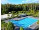 Aerial view of the community pool featuring a lap pool, lounge chairs, pergolas, and a basketball court at 32484 Worden Pass, Wesley Chapel, FL 33543