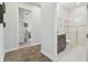 Hallway view into a bathroom with a glass shower enclosure and dark wood flooring at 32484 Worden Pass, Wesley Chapel, FL 33543