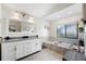 Bright bathroom with a double vanity, soaking tub, window, and contemporary finishes at 3275 Valemoor Dr, Palm Harbor, FL 34685