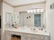 Bathroom with white countertops, a decorative mirror, and ample storage at 335 Stroll Ln, Sun City Center, FL 33573