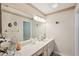 Bathroom with white countertops, a decorative mirror, and ample lighting at 335 Stroll Ln, Sun City Center, FL 33573