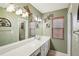 Bathroom with white countertops, decorative mirror, light green walls and lizard art at 335 Stroll Ln, Sun City Center, FL 33573