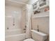 Bathroom featuring a white tiled tub and shower combination with floral wallpaper at 335 Stroll Ln, Sun City Center, FL 33573
