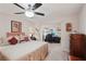 Cozy bedroom with a ceiling fan, neutral tones, and a sliding glass door to the office at 335 Stroll Ln, Sun City Center, FL 33573