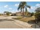 Attractive home featuring a well-kept lawn, a paved driveway, and mature palm trees for a tropical feel at 335 Stroll Ln, Sun City Center, FL 33573