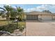 Charming single-story home featuring a brick driveway and well-manicured front yard at 335 Stroll Ln, Sun City Center, FL 33573