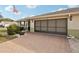 Single-story home featuring a brick driveway, well-maintained landscaping, and American flag at 335 Stroll Ln, Sun City Center, FL 33573