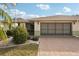Charming single-story home with a brick driveway, a two-car garage, and well-maintained landscaping at 335 Stroll Ln, Sun City Center, FL 33573