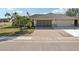 Charming home features a brick driveway, manicured lawn, and two-car garage at 335 Stroll Ln, Sun City Center, FL 33573