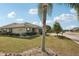 Pleasant home exterior with a well-manicured lawn, palm trees, and clean landscaping details at 335 Stroll Ln, Sun City Center, FL 33573