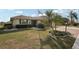 Landscaped front yard with a well-maintained lawn, mature trees, and an American flag flying high at 335 Stroll Ln, Sun City Center, FL 33573