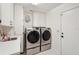 Laundry room featuring front loading washer and dryer with storage cabinets at 335 Stroll Ln, Sun City Center, FL 33573