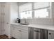 Bright kitchen area with white cabinets, stainless steel dishwasher and a modern sink at 337 15Th N St, St Petersburg, FL 33705