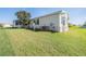 Home featuring a well maintained lawn, mature landscaping, and outdoor AC unit at 37508 Gill Ave, Zephyrhills, FL 33541