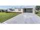 Charming home with a well-manicured lawn and long driveway leading to a covered parking area at 37508 Gill Ave, Zephyrhills, FL 33541