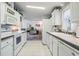 Galley kitchen with white appliances, tile flooring, and ample cabinet space at 37508 Gill Ave, Zephyrhills, FL 33541