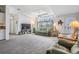 Bright living room featuring plush carpeting, high tray ceilings, and comfortable seating at 37508 Gill Ave, Zephyrhills, FL 33541