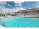 Outdoor community pool with a lifeguard ring under cloudy skies with recreational building in the background at 37508 Gill Ave, Zephyrhills, FL 33541