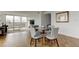 Stylish dining area with a glass table, grey upholstered chairs, and hardwood floors with a view of the city at 400 Island Way # 612, Clearwater Beach, FL 33767