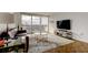 Bright living room with a brown leather sofa, hardwood floors, floor-to-ceiling windows with city views, and modern decor at 400 Island Way # 612, Clearwater Beach, FL 33767