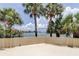 Waterside patio featuring lush greenery, palm trees, and panoramic water views at 400 Island Way # 612, Clearwater Beach, FL 33767