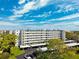 View of the building featuring covered parking and manicured greenery at 4240 Ironwood Cir # 404, Bradenton, FL 34209
