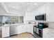 Clean, bright kitchen with stainless appliances, white cabinets, and a pass-through opening to the living area at 4240 Ironwood Cir # 404, Bradenton, FL 34209