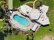 Aerial view of a kidney-shaped pool with lounge chairs and a building with a unique architectural design at 4240 Ironwood Cir # 404, Bradenton, FL 34209