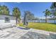 Backyard showcasing a paver patio, green lawn, white vinyl fence, and palm trees at 4419 Huntington Ne St, St Petersburg, FL 33703