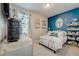 Cozy bedroom featuring an eye-catching blue accent wall, plush bedding, and decorative shelving at 5030 Jagged Cloud Dr, Wimauma, FL 33598