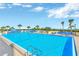 Outdoor swimming pool with plenty of lounge chairs, umbrellas, and scenic lake views at 5915 Sea Ranch Dr # 307, Hudson, FL 34667