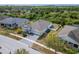Stunning aerial view of a home with a well-manicured lawn and landscaping surrounded by lush trees at 618 Manns Harbor Dr, Apollo Beach, FL 33572