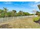 Spacious backyard features a well-maintained lawn, mature trees, and a classic white picket fence at 618 Manns Harbor Dr, Apollo Beach, FL 33572