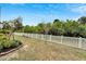 Beautiful backyard with lush landscaping, mature trees, and a classic white picket fence at 618 Manns Harbor Dr, Apollo Beach, FL 33572