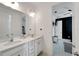 Bathroom with double sinks, bright lighting, and doorway view to a bedroom at 618 Manns Harbor Dr, Apollo Beach, FL 33572
