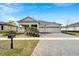 Charming home boasts a three-car garage, well-manicured lawn, and inviting front porch with stately columns at 618 Manns Harbor Dr, Apollo Beach, FL 33572