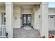 Covered front porch with stately columns, double glass doors, and elegant paver flooring at 618 Manns Harbor Dr, Apollo Beach, FL 33572