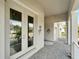 Charming front porch with tiled flooring, white railings, and views of lush greenery at 618 Manns Harbor Dr, Apollo Beach, FL 33572