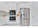 White kitchen featuring built-in stainless appliances including double ovens and a refrigerator at 618 Manns Harbor Dr, Apollo Beach, FL 33572