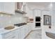 Modern white kitchen with stainless steel appliances, gas cooktop, and ample countertop space at 618 Manns Harbor Dr, Apollo Beach, FL 33572