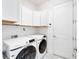 Bright laundry room with white cabinets and modern Samsung front-load washer and dryer at 618 Manns Harbor Dr, Apollo Beach, FL 33572