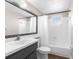 Bathroom featuring white tile, tub, shower, light vanity and sink, with gray painted wood below the sink at 6840 Mesa Verde St, Port Richey, FL 34668