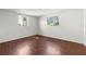 Bedroom with light walls and wood-look floors, brightened by natural light from two windows at 6840 Mesa Verde St, Port Richey, FL 34668