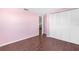 Bright bedroom features wood-look floors, pink walls, and a closet for ample storage at 6840 Mesa Verde St, Port Richey, FL 34668