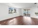 Bright living room with hardwood floors, large windows, and sliding glass door to lanai at 6840 Mesa Verde St, Port Richey, FL 34668