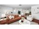 Bright living room with a brown leather couch, patterned rug, and dining table set for elegant dinners at 6840 Mesa Verde St, Port Richey, FL 34668